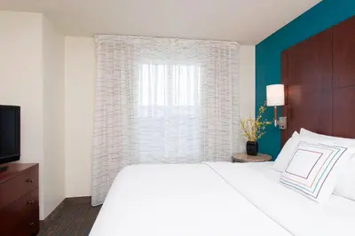 a bedroom with a white bed and a window at Residence Inn Toledo Maumee in Maumee