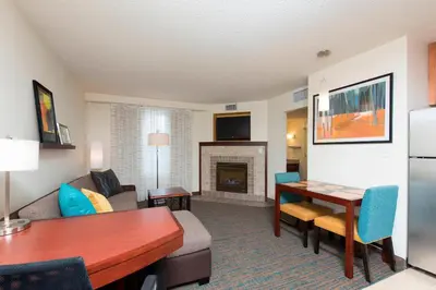 a living room with a couch a table and a fireplace at Residence Inn Toledo Maumee in Maumee