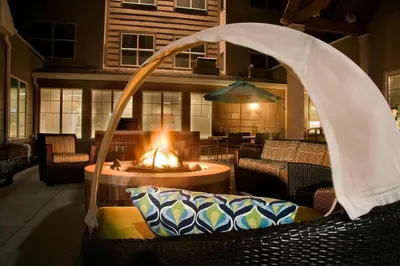 a patio with a fireplace and a chair with a table at Residence Inn Toledo Maumee in Maumee