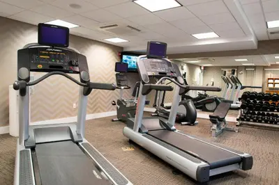 a gym with treadmills and elliptical machines at Residence Inn Toledo Maumee in Maumee