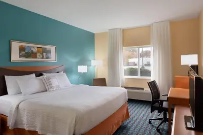 a hotel room with a bed and a desk and a window at Fairfield Inn & Suites Youngstown Boardman Poland in Poland
