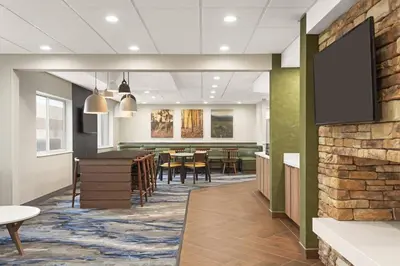 a dining room with a table and a tv on a wall at Fairfield Inn by Marriott Warren Niles in Warren