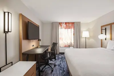 a hotel room with a bed and a desk with a computer at Fairfield Inn by Marriott Warren Niles in Warren