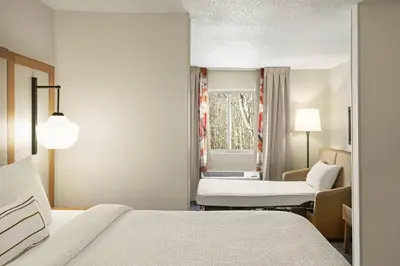 a hotel room with a bed and a chair at Fairfield Inn by Marriott Warren Niles in Warren