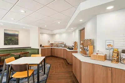 a restaurant with a counter and tables and chairs at Fairfield Inn by Marriott Warren Niles in Warren