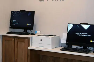 two computer monitors and a printer on a desk at Fairfield by Marriott Youngstown/Austintown in Youngstown