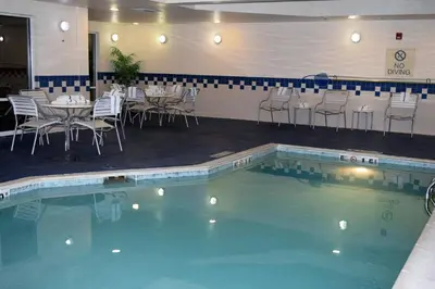 a swimming pool with tables and chairs in a restaurant at Fairfield by Marriott Youngstown/Austintown in Youngstown