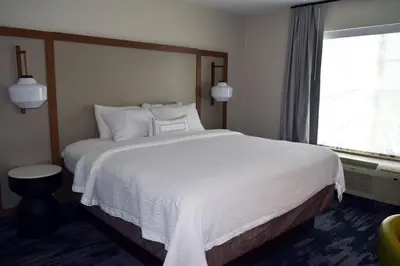 a bedroom with a large white bed with a window at Fairfield by Marriott Youngstown/Austintown in Youngstown