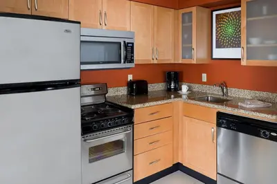 a kitchen with wooden cabinets and stainless steel appliances at Residence Inn Youngstown Boardman/Poland in Poland