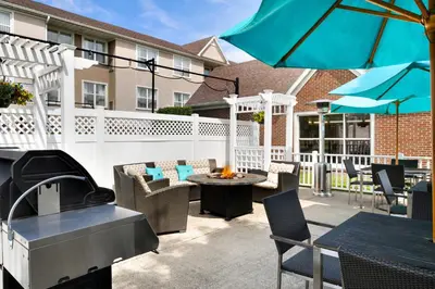 a patio with chairs and tables and an umbrella at Residence Inn Youngstown Boardman/Poland in Poland