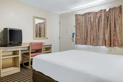 a hotel room with a bed and a television at Rodeway Inn Sharonville - Cincinnati North in Sharonville