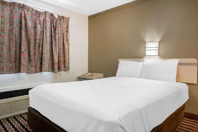 a bedroom with a large bed and a window at Rodeway Inn Sharonville - Cincinnati North in Sharonville