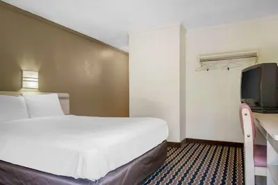 a hotel room with a bed and a tv at Rodeway Inn Sharonville - Cincinnati North in Sharonville
