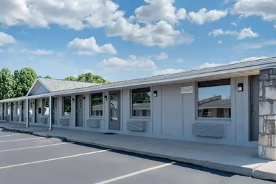 a white building with windows on a parking lot at Rodeway Inn Sharonville - Cincinnati North in Sharonville