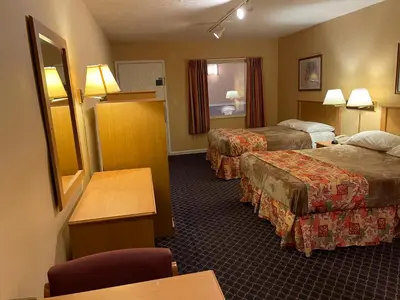 a hotel room with two beds and a table at Wildwood Inn in Florence