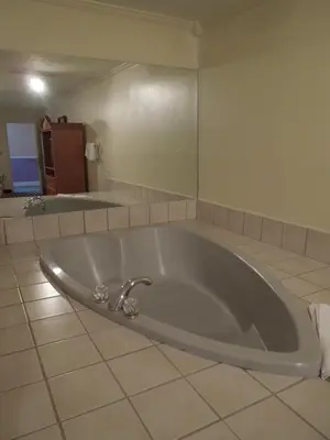 a large tub in a bathroom with a tile floor at Wildwood Inn in Florence