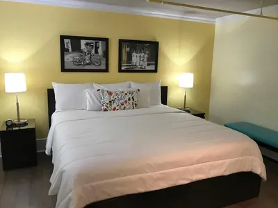 a bedroom with a large white bed with two lamps at The Sherman Inn in Batesville