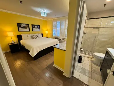 a bedroom with a bed and a bathroom with a shower at The Sherman Inn in Batesville