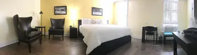 a bedroom with a bed and two chairs at The Sherman Inn in Batesville