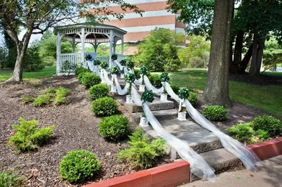 a garden with a white fence and a gazebo at Ramada by Wyndham Cleveland Independence in Independence