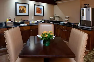 a kitchen with a table with a vase of flowers on it at Ramada by Wyndham Cleveland Independence in Independence