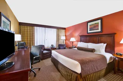 a hotel room with a bed and a flat screen tv at Ramada by Wyndham Cleveland Independence in Independence