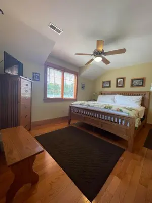 a bedroom with a bed and a ceiling fan at Bodee's Bungalow Adults Only Couples Only Boutique Hotel in Put-in-Bay