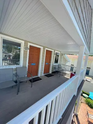 a porch with benches and chairs on a house at Bodee's Bungalow Adults Only Couples Only Boutique Hotel in Put-in-Bay