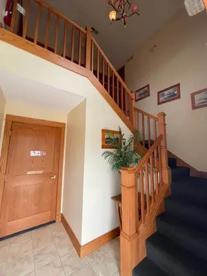 a hallway with stairs and a wooden door at Bodee's Bungalow Adults Only Couples Only Boutique Hotel in Put-in-Bay