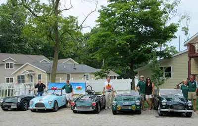 a group of people standing next to three old cars at Ahoy Inn Guesthouse in Put-in-Bay
