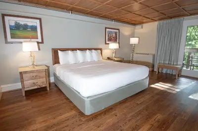 a bedroom with a large bed and two lamps on tables at Carter Caves State Resort Park in Olive Hill