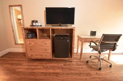 a desk with a television and a chair in a room at Carter Caves State Resort Park in Olive Hill