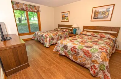 a bedroom with two beds and a television in it at Carter Caves State Resort Park in Olive Hill