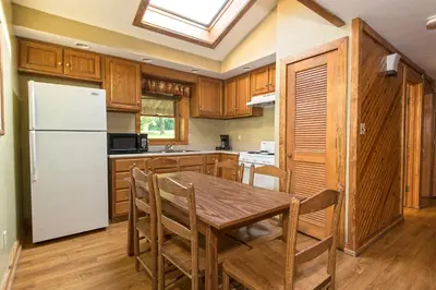 a kitchen with a wooden table and a white refrigerator at General Butler State Resort Park in Carrollton