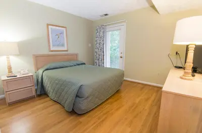 a bedroom with a bed and a wooden floor at General Butler State Resort Park in Carrollton