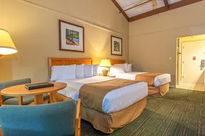 a hotel room with two beds and a table and a chair at Greenbo Lake State Resort Park in Argillite