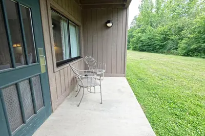 two chairs sitting on a porch next to a window at Blue Licks Battlefield State Park in Carlisle