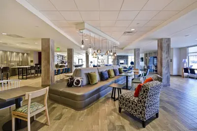 a large living room with a couch and chairs at Home2 Suites by Hilton Perrysburg Levis Commons Toledo in Perrysburg