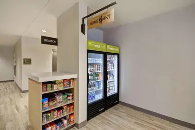 a grocery store aisle with a refrigerator in a store at Home2 Suites by Hilton Perrysburg Levis Commons Toledo in Perrysburg
