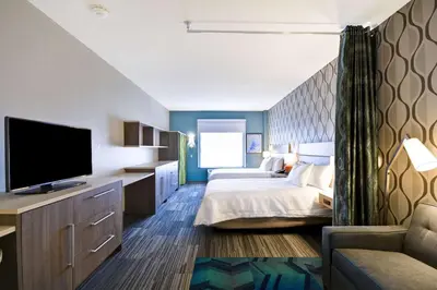 a bedroom with two beds and a flat screen tv at Home2 Suites by Hilton Perrysburg Levis Commons Toledo in Perrysburg