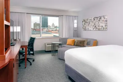 a hotel room with a bed and a desk at Courtyard Fort Wayne Downtown at Grand Wayne Convention Center in Fort Wayne
