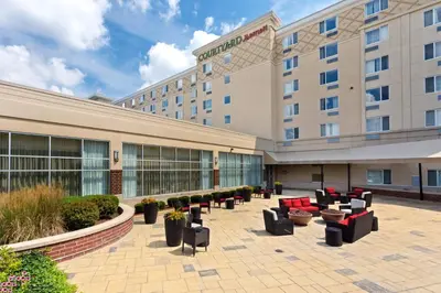 a hotel courtyard with couches and chairs in front of a building at Courtyard Fort Wayne Downtown at Grand Wayne Convention Center in Fort Wayne