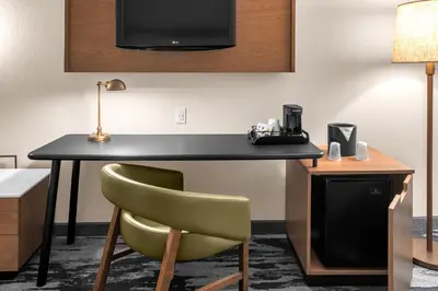 a room with a desk with a chair and a television at Fairfield by Marriott Inn & Suites Columbus Hilliard in Columbus