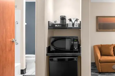 a room with a microwave and a television and a chair at Fairfield by Marriott Inn & Suites Columbus Hilliard in Columbus