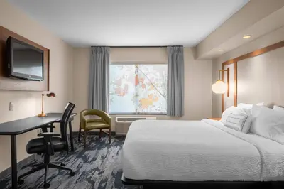 a hotel room with a bed and a desk and a window at Fairfield by Marriott Inn & Suites Columbus Hilliard in Columbus