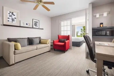 a living room with a couch and a red chair at Country Inn & Suites by Radisson, Springfield, OH in Springfield