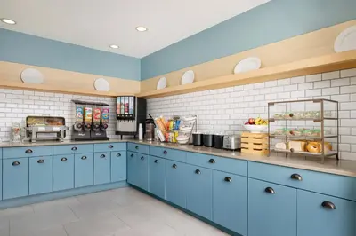 a large kitchen with blue cabinets and white tiles at Country Inn & Suites by Radisson, Springfield, OH in Springfield