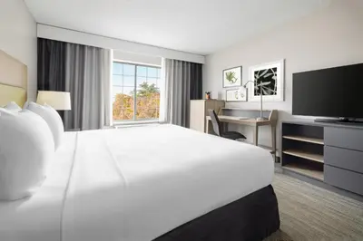 a hotel room with a large white bed and a desk at Country Inn & Suites by Radisson, Springfield, OH in Springfield