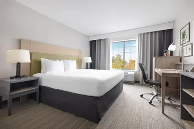a hotel room with a large bed and a desk at Country Inn & Suites by Radisson, Springfield, OH in Springfield