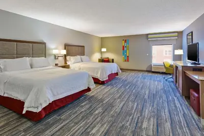 a hotel room with two beds and a flat screen tv at Hampton Inn Cincinnati Airport-North in Hebron